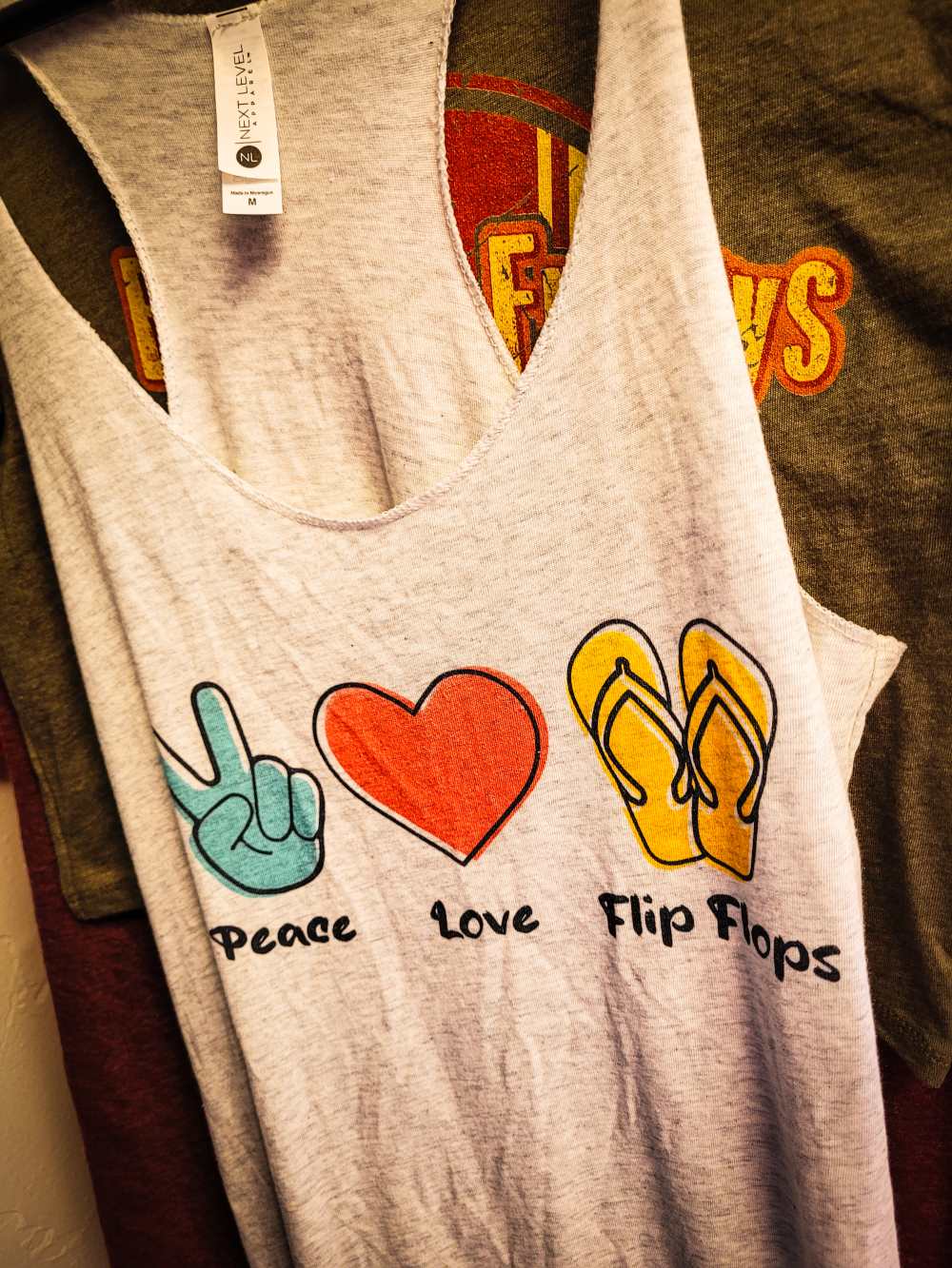 Embrace Summer Vibes with the "Peace, Love, Flip Flops" Raw Edge Tank Top by Next Level